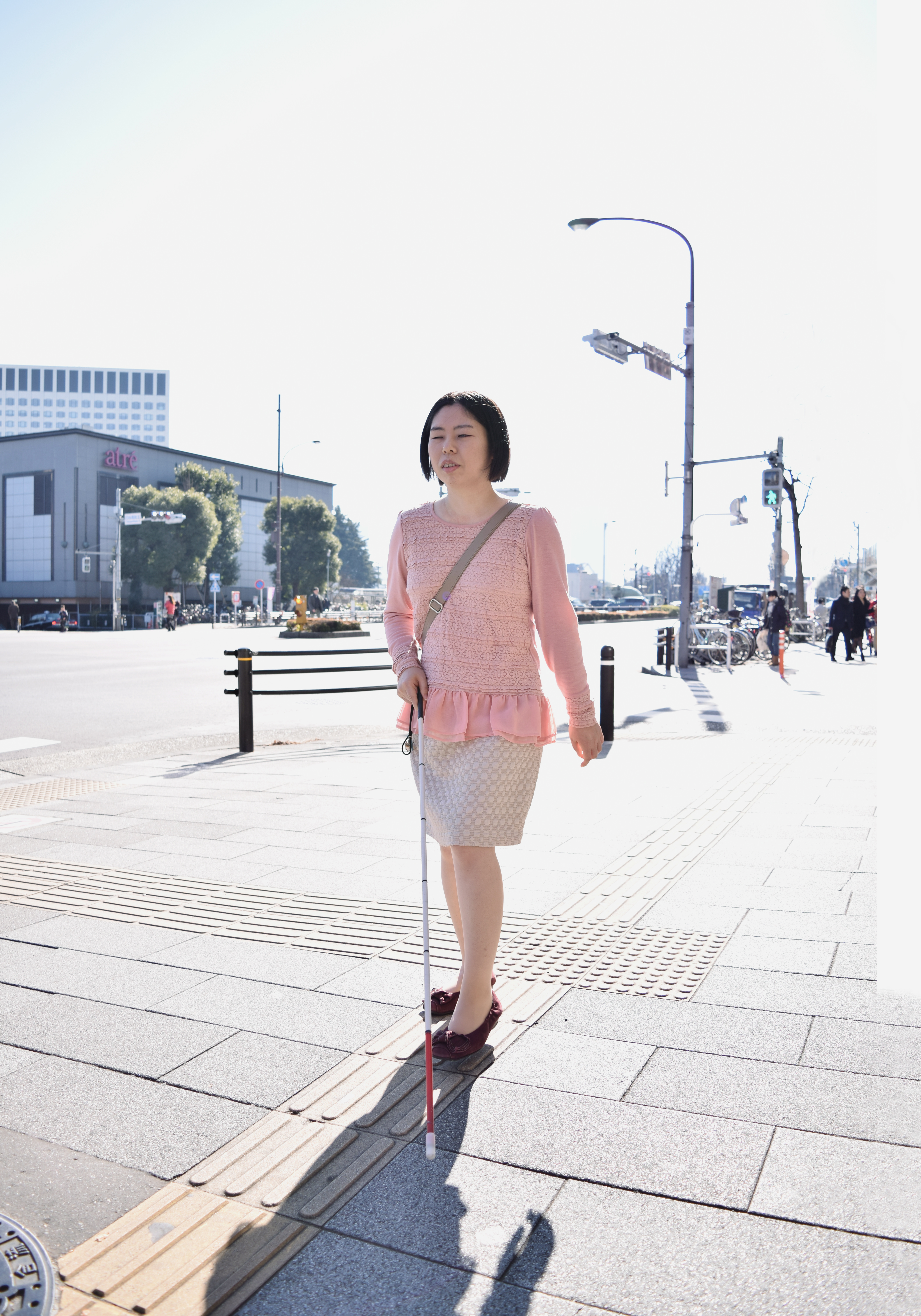【移動】白杖をもって颯爽と街を歩く若い女性。訓練を受けることで、安全、かつ自由に移動することができます。