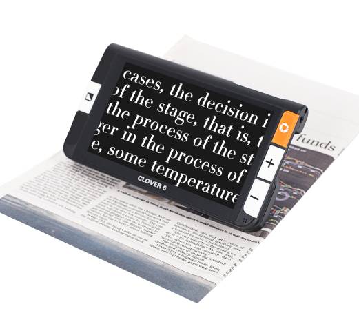 写真:携帯拡大読書器(英字新聞の上に置かれた携帯拡大読書器には、黒い背景で白い文字で拡大表示されている)